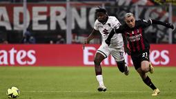 Bek AC Milan, Sergino Dest berlari berebut bola dengan pemain Torino, Stephane Singo pada pertandingan babak 16 besar Coppa Italia di Stadion San Siro di Milan, Italia, Kamis (12/1/2023). Torino menang tipis atas AC Milan dengan skor 1-0 berkat gol Michel Adopo di perpanjangan waktu. (Marco Alpozzi/LaPresse via AP)