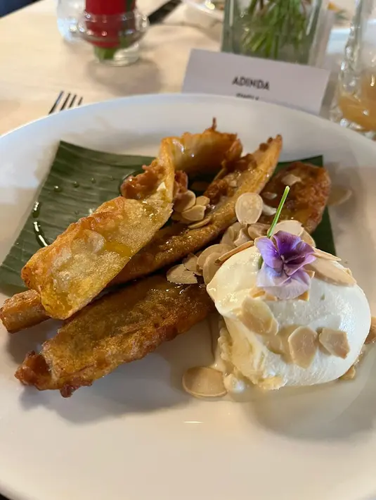 Untuk Anda yang cinta dengan aneka menu berbahan dasar pisang, wajib mencicipi menu ini. Banana Fritters yang diproses hingga berselimutkan karamel, berpadu selaras dengan ice cream dan taburan almond. Lezat! [ Foto: Adinda Tri Wardhani - Fimela.com.]