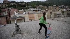 Vittoria Oliveri (depan) bermain tenis dengan Carola di atas atap rumah mereka selama lockdown COVID-19 di Finale Ligure, Wilayah Liguria, Italia (19/4/2020). Setiap hari Carola, 11, dan Vittoria, 13, bermain tenis dari satu atap ke atap lain di rumah mereka untuk berlatih. (AFP/Marco Bertorello)