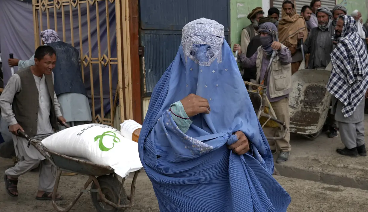 <p>Seorang perempuan Afghanistan menunggu untuk menerima jatah makanan yang didistribusikan oleh kelompok bantuan kemanusiaan Korea Selatan, di Kabul, Selasa (10/5/2022). Taliban pada Sabtu pekan lalu memerintahkan semua perempuan Afghanistan menutupi seluruh tubuhnya atau mengenakan burqa tradisional di depan umum. (AP Photo/Ebrahim Noroozi)</p>