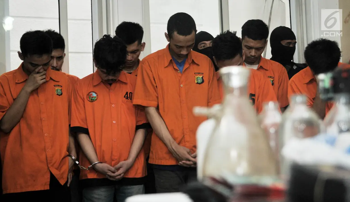 Tersangka tertunduk saat rilis pengembangan kasus pembuatan liquid vape narkoba di Kelapa Gading, Jakarta, Kamis (8/11). Sebelumnya, polisi juga telah meringkus 13 tersangka. (Merdeka.com/Iqbal Nugroho)