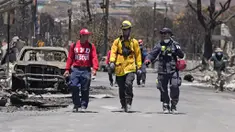 Anggota tim SAR berjalan melewati sisa-sisa kerusakan parah akibat kebakaran hutan di Lahaina, Hawaii, Amerika Serikat, Sabtu (12/8/2023). Jumlah korban tewas akibat kebakaran hutan Hawaii sekarang mencapai 89 orang, kata para pejabat pada Sabtu 12 Agustus 2023 waktu setempat. (AP Photo/Rick Bowmer)