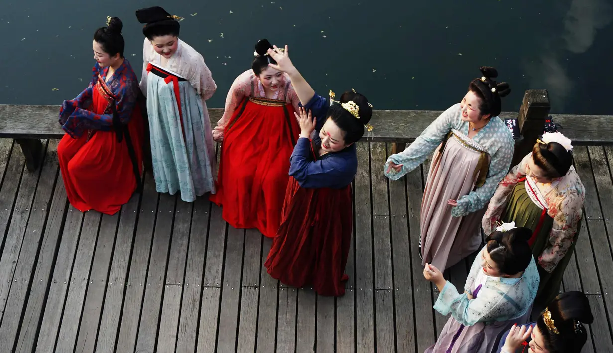 Sejumlah wanita mengenakan kostum Dinasti Tang saat mengunjungi Danau Barat di Hangzhou di provinsi Zhejiang timur China (31/3). Bahan pakaian Dinasti Tang terbuat dari sutra dan terkenal karena kelembutan dan ringan.  (AFP Photo/China Out)