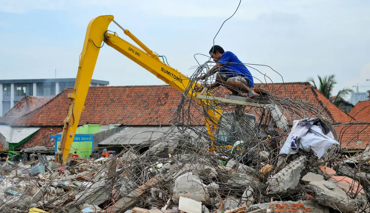 Seorang pria berusaha mengambil sisa-sisa besi dari bangunan yang dirobohkan di kawasan Pasar Ikan, Penjaringan, Jakarta, Selasa (12/4). Selain warga, sejumlah pemulung besi berhambur untuk menjarah besi dari bekas bangunan (Liputan6.com/Yoppy Renato)
