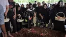 Aktris Olla Ramlan menaburkan bunga saat proses pemakaman sang ayahanda, Muhammad Ramlan di TPU Tanah Kusir, Jakarta, Selasa (5/6). Ayahanda Olla Ramlan meninggal di usia 72 tahun akibat kanker dan liver yang dideritanya. (Liputan6.com/Faizal Fanani)