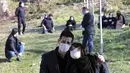 Seorang pria merangkul wanita saat pemakaman korban yang meninggal karena COVID-19 di sebuah pemakaman pinggiran Kota Ghaemshahr, Iran, 17 Desember 2020. Iran mengatakan pada hari Kamis (18/13) sekitar 60 ribu perawatnya telah terinfeksi COVID-19. (AP Photo/Ebrahim Noroozi)