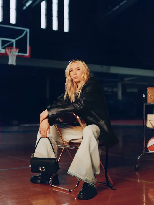Paige Bueckers dari Dallas Wings tampil dengan jaket leather hitam dipadukan celana denim panjang. Ia membawa tas Coach hitam. [Coach]