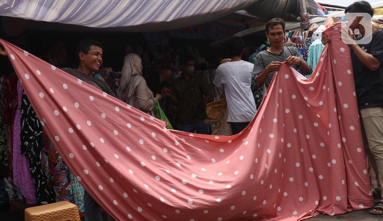Pedagang mengukur kain dagangan di kawasan Pasar Cipadu, Tangerang, Selasa (2/3/2021). Pandemi Covid-19 membuat industri tekstil dan pakaian jadi mengalami pertumbuhan negatif 8, 8 persen sepanjang 2020 dengan kinerja ekspor yang berkontraksi 17 persen. (Liputan6.com/Angga Yuniar)