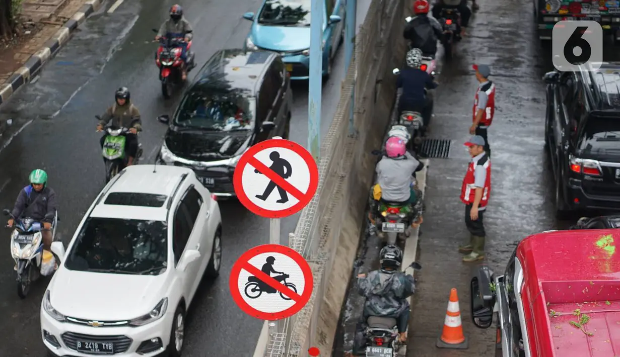 Pengendara motor melintasi Gerbang Tol Lenteng Agung 2 di Tanjung Barat, Jakarta, Rabu (1/1/2020). Banjir yang menggenangi Jalan TB Simatupang menyebabkan akses bagi pengendara terputus sehingga membuat arus lalu lintas seluruh kendaraan dialihkan melalui jalan tol. (Liputan6.com/Immanuel Antonius)