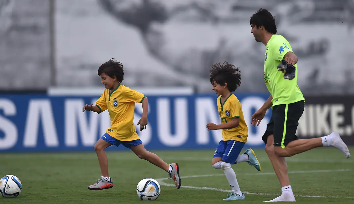 Pemain Brasil, Kaka berlatih didampingi putranya yang bernama Luca saat persiapan jelang laga penyisihan Piala Dunia 2018 melawan Argentina di Sao Paulo, Brasil, Selasa (10/11/2015). (AFP Photo/Nelson Almeida) 