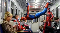 Penari underground yang mengenakan kostum Spiderman tampil di kereta bawah tanah Saint Petersburg, Rusia pada 21 Mei 2021. Penari berkostum Spiderman tersebut tampil berjungkir, melompat dan melakukan gerakan akrobatik di kabin kereta bawah tanah. (Olga MALTSEVA / AFP)