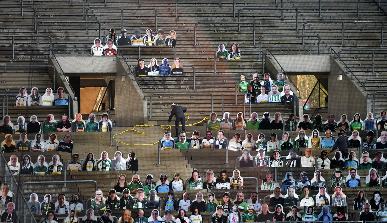 Cardboard pendukung Borussia Moenchegladbach mengisi kursi penonton di stadion Borussia Park, Moenchengladbach, Jerman, Rabu (20/5/2020). Ribuan Cardboard gambar suporter Borussia Moenchegladbach dipasang untuk mendukung timnya saat berlaga di kompetisi Bundesliga. (AFP/Ina Fassbender)