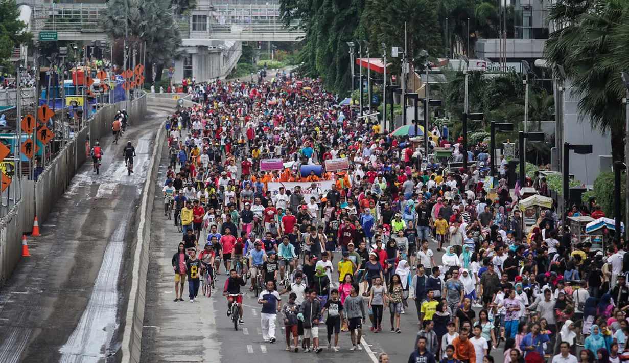 Ribuan orang memadati jalan MH Thamrin Jakarta saat Hari Bebas Kendaraan Bermotor (HBKB) terakhir di tahun 2014, Jakarta, Minggu (28/12/2014). (Liputan6.com/Faizal Fanani)