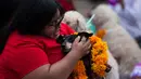 Seorang wanita memeluk anjingnya yang diberikan kalung selama acara "Kukur Tihar" di Mexico City, Minggu (11/11). Kukur Tihar adalah festival Hindu yang dirayakan khusus untuk menghormati anjing. (AP Photo/Claudio Cruz)