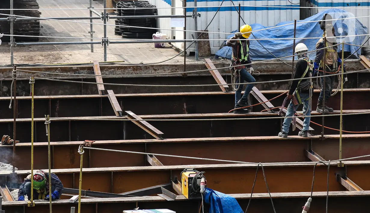 Pekerja menyelesaikan proyek Moda Raya Terpadu (MRT) Fase II di Jalan MH Thamrin, Jakarta, Selasa (19/7/2022). Proyek MRT Jakarta Fase 2 CP 201 rute Stasiun Thamrin-Stasiun Monas telah mencapai 40,25 persen. (Liputan6.com/Faizal Fanani)