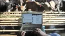 Azmi menggunakan laptop saat menjawab pertanyaan konsumen via website dan media sosial di Peternakan Yuk Qurban, Depok, Rabu (22/7/2020). Menurut Pemilik peternakan Yuk Qurban itu penjualan hewan kurban melalui daring disambut antusias masyarakat dan terus meningkat. (merdeka.com/Iqbal Nugroho)