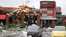Seorang pria berdiri mengamati restoran yang ambruk akibat tornado di Tusla, Oklahoma, Minggu (6/8). Badai menyebabkan pemadaman listrik lebih dari 11.000 bangunan dan kerusakan di setiap sudut kota Tusla. (Tulsa World via AP/Tom Gilbert)