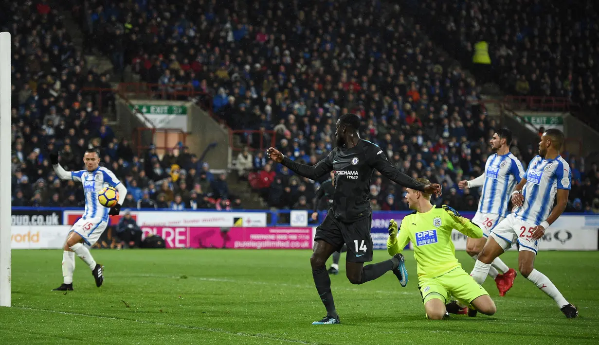 Pemain Chelsea, Tiemoue Bakayoko mencetal gol melewati kiper Huddersfield Town, Jonas Lossi pada lanjutan pertandingan Premier League di Stadion The John Smith's, Selasa (12/12). Chelsea menaklukkan Huddersfield Town dengan skor 3-1. (Oli SCARFF / AFP)