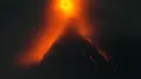Dari kejauhan pada Minggu malam, tim wartawan Associated Press menyaksikan gunung berapi tersebut memuntahkan lava ke selokan-selokan di bagian tenggara selama berjam-jam. (AP Photo/Aaron Favila)