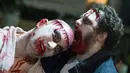 Sejumlah peserta mengenakan kostum menyerupai zombie berpose saat mengikuti perayaan hari Purim di Tel Aviv (11/3). Purim merupakan hari raya atau pesta Yahudi untuk memperingati pembebasan kaum Yahudi dari kekaisaran Persia. (AFP/Jack Guez)