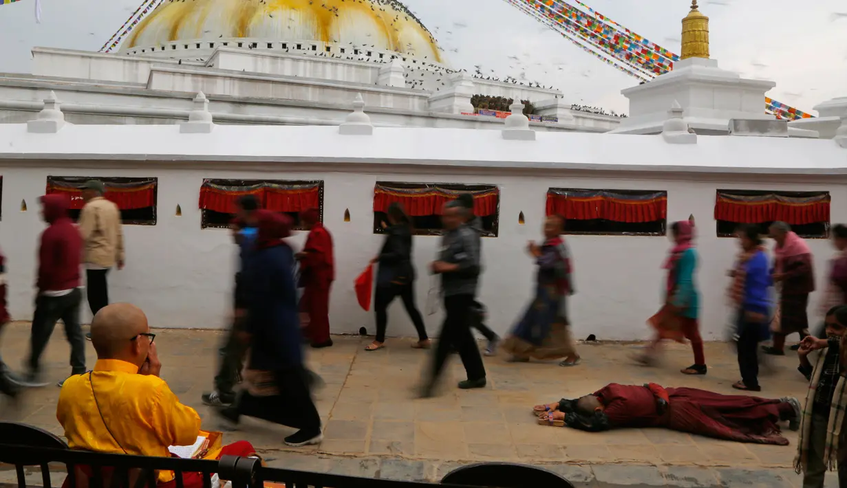 Seorang biksu bersujud selama Buddha Jayanti atau Buddha purnima di stupa Boudhanath, Kathmandu, Nepal (30/4). Festival ini menandai tiga peristiwa kehidupan Buddha Gautama. (AP/Niranjan Shrestha)