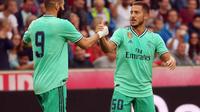 Selebrasi Eden Hazard bersama Karim Benzema setelah menjebol gawang Real Bull Salzburg dalam laga persahabatan di Austria (7/8/2019). (APA/AFP/Krugfoto)