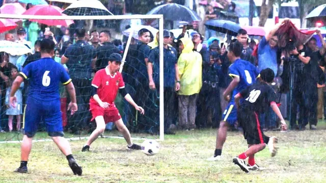 Presiden Jokowi main sepak bola di Sleman di bawah hujan deras. (Foto: