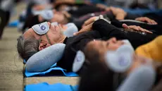 Orang-orang menikmati tidur siang saat menghadiri acara Hari Tidur Sedunia (World Sleep Day) di Monumento a la Revolution, Mexico City, Meksiko, pada 15 Maret 2024. (Rodrigo Oropeza/AFP)