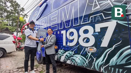 GM Arema, Yusrinal Fitriandi (kiri) secar simbolis menerima bus dari Komisaris J99 Corp Sidik Widjanarko di depan kantor manajemen arema, Selasa (4/7/2023). (Bola.com/Iwan Setiawan)