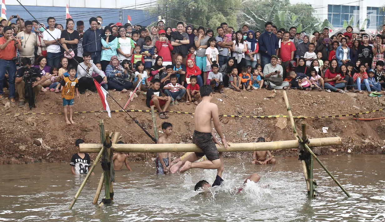 Seorang peserta terjatuh ke air saat mengikuti lomba gebuk bantal dalam Festival Kalimalang di Cipinang Melayu, Jakarta Timur, Kamis (17/8). Festival Kalimalang ini dalam rangka memeriahkan HUT ke-72 RI. (Liputan6.com/Herman Zakharia)