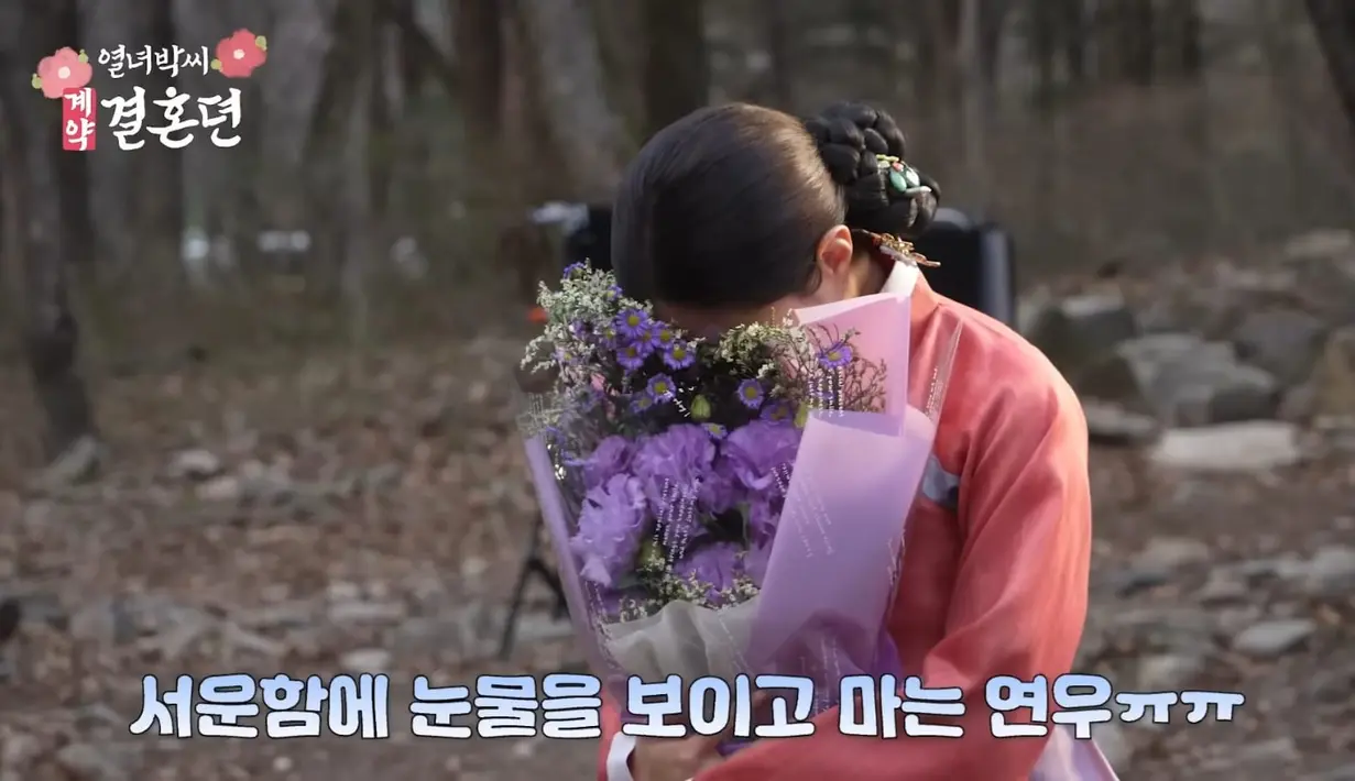 Lee Se Young menyembungikan wajahnya dengan buket bunga krena menangis. Dia tentu sedih karena harus berpisah setelah 7 bulan syuting. "Aku akan sangat merindukan kalian semua." (Foto: YouTube/ MBCdrama)