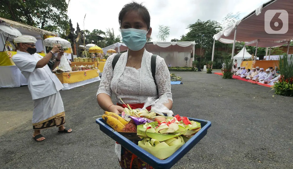 Umat Hindu membawa sesajen saat Upacara Tawur Agung Kesanga di Pura Aditya Jaya, Pulo Gadung, Jakarta Timur, Rabu (1/3/2022). Upacara Tawur Agung merupakan simbol ritual penyucian alam semesta yang dilaksanakan sehari sebelum Catur Brata Penyepian atau Hari Suci Nyepi. (Liputan6.com/Herman Zakharia)