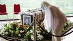 Seorang wanita berada dekat peti jenazah almarhum Ketua Umum Pengurus Besar Persatuan Atletik Seluruh Indonesia (PB PASI) Bob Hasan di Jakarta, Selasa (31/3/2020). Bob Hasan meninggal dunia di RSPAD Gatot Subroto Jakarta setelah sempat dirawat intensif selama tiga bulan. (Liputan6.com/Faizal Fanani)