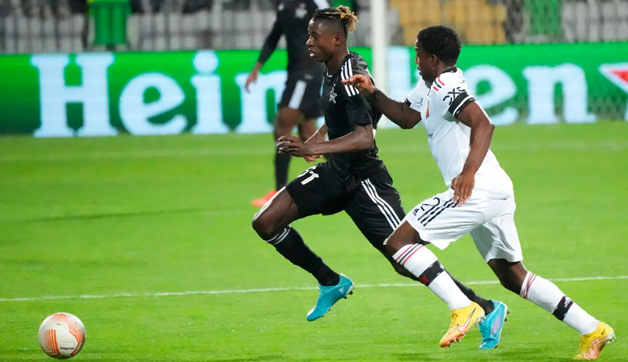 Pemain Sheriff Tiraspol Rasheed Akanbi (kiri) berebut bola dengan pemain Manchester United Tyrell Malacia pada pertandingan sepak bola Grup E Liga Europa di Stadion Zimbru, Chisinau, Moldova, 15 September 2022. Manchester United menang 2-0. (AP Photo/Sergei Grits)