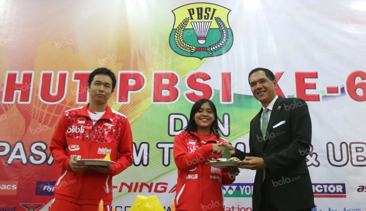 Ketua Umum PBSI, Gita Wirjawan (kanan), menyerahkan potongan tumpeng kepada Hendra Setiawan (kiri) dan Gregoria Mariska dalam perayaan HUT PBSI ke-65 di Pelatnas Bulutangkis PBSI, Cipayung, Jakarta, (9/5/2016). (Bola.com/Arief Bagus)