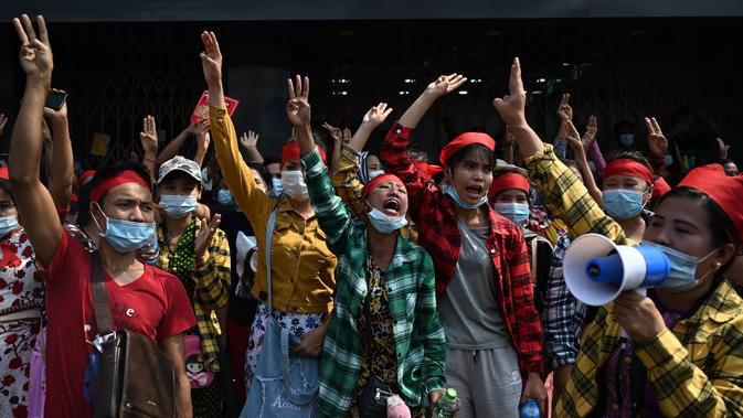 Para pengunjuk rasa mengacungkan salam tiga jari saat demonstrasi menentang kudeta militer di Yangon, Myanmar pada Sabtu (6/2/2021). Penangkapan Suu Kyi dan para pemimpin senior lainnya minggu ini menghentikan pemerintahan demokrasi selama 10 tahun terakhir. (YE AUNG THU / AFP)