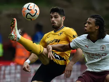 Pemain Wolverhampton Wanderers Pedro Neto (kiri) mengontrol bola melewati pemain Manchester City Nathan Ake pada pertandingan sepak bola Liga Inggris di Stadion Molineux, Wolverhampton, Inggris, Sabtu (30/9/2023). Wolverhampton Wanderers mengalahkan Manchester City dengan skor 2-1. (AP Photo/ Rui Vieira)