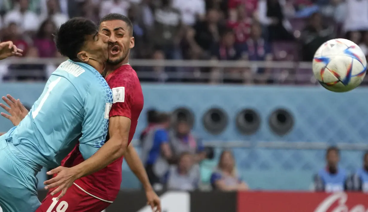 Kiper Timnas Iran Alireza Beiranvand bertabrakan dengan rekan setimnya Majid Hosseini (kanan) saat pertandingan sepak bola grup B Piala Dunia Qatar 2022 antara Inggris dan Iran di Stadion Internasional Khalifa, Doha, Qatar, Senin (21/11/2022). Kejadian ini berawal dari seorang pemain Inggris yang melepas umpan silang dan melambung ke wilayah kotak penalti timnas Iran. (AP Photo/Alessandra Tarantino)