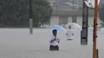 Orang-orang menyeberang jalan akibat hujan lebat di Kurume, Prefektur Fukuoka, Jepang selatan Senin, 10 Juli 2023. (Kyodo News via AP)