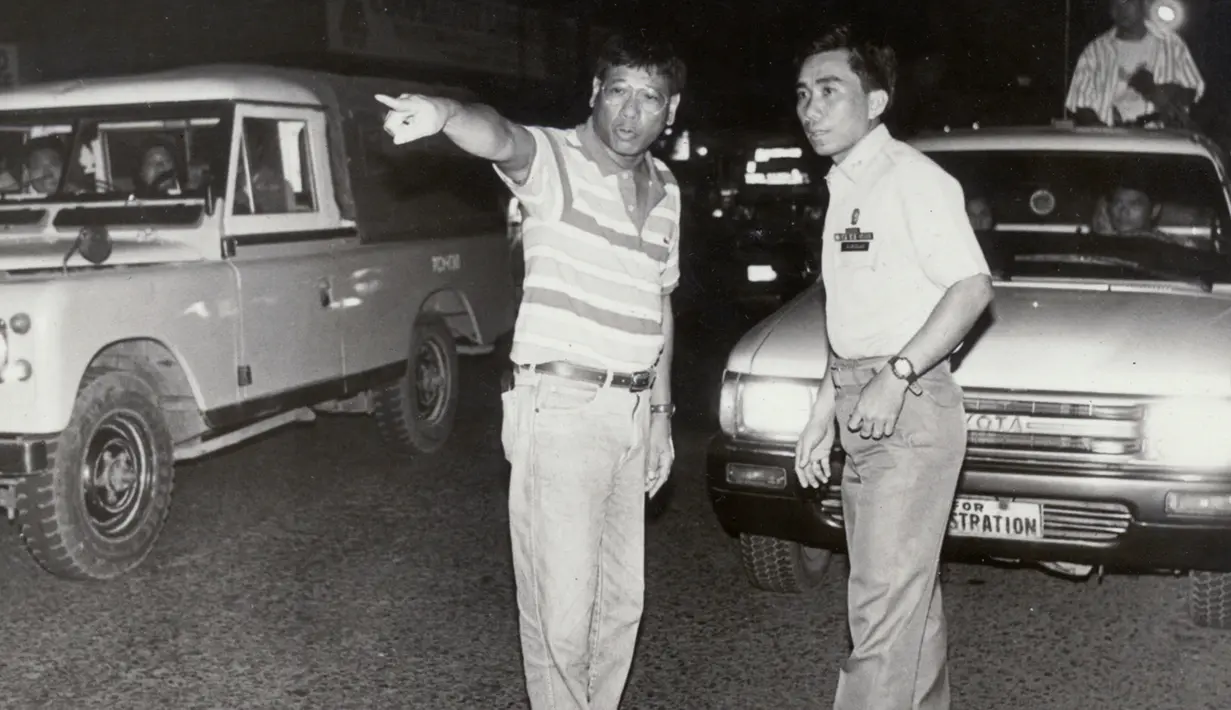 Gambar yang diambil pada awal 1990-an memperlihatkan Rodrigo Duterte (kiri) yang masih menjabat sebagai Wali Kota Davao, membantu seorang polisi untuk mengatur kemacetan lalu lintas di jalanan pusat kota Davao, Filipina selatan. (REUTERS/Renato Lumawag)