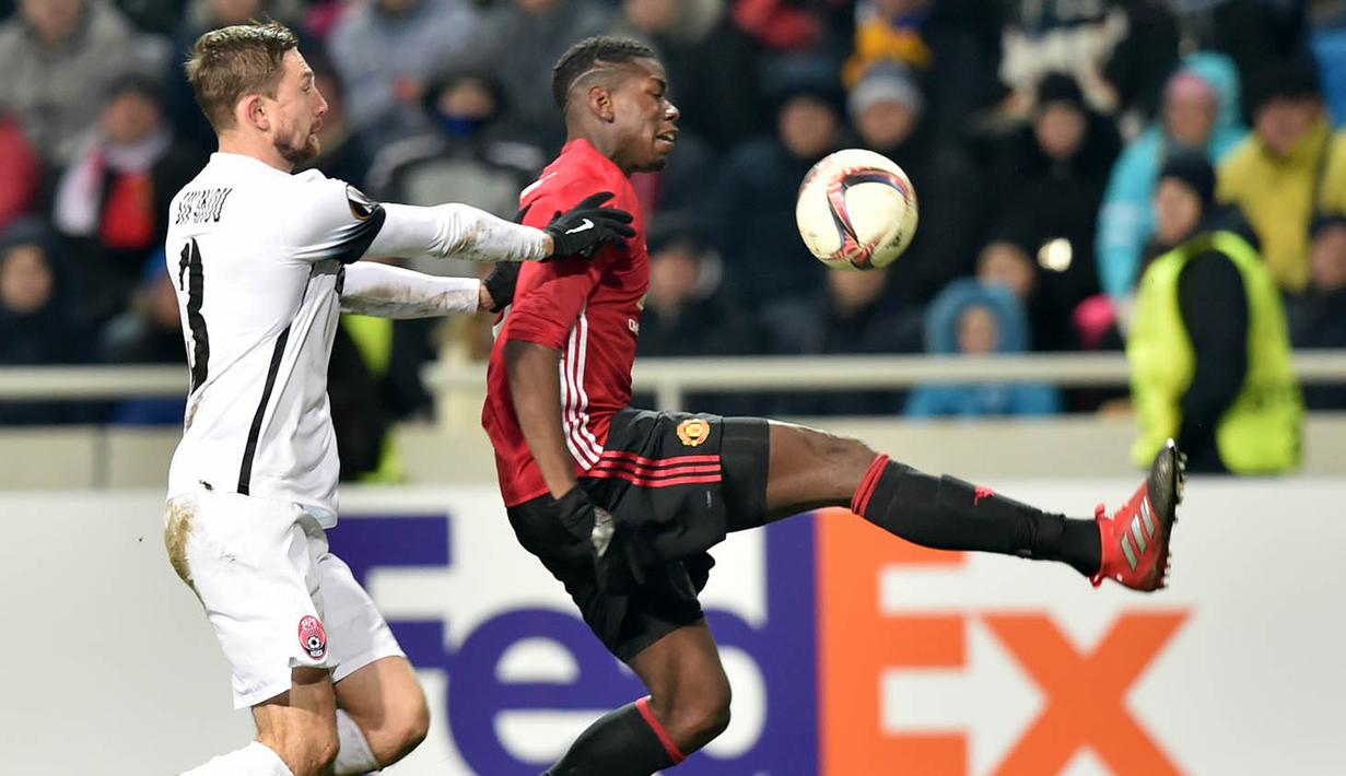 Gelandang Manchester United, Paul Pogba, berusaha melewati gelandang FC Zorya Luhansk, Yevhen Opanasenko. Pada laga ini MU melakukan enam kali tembakan ke arah gawang, sementara Zorya hanya dua kali. (AFP/Sergei Supinsky)