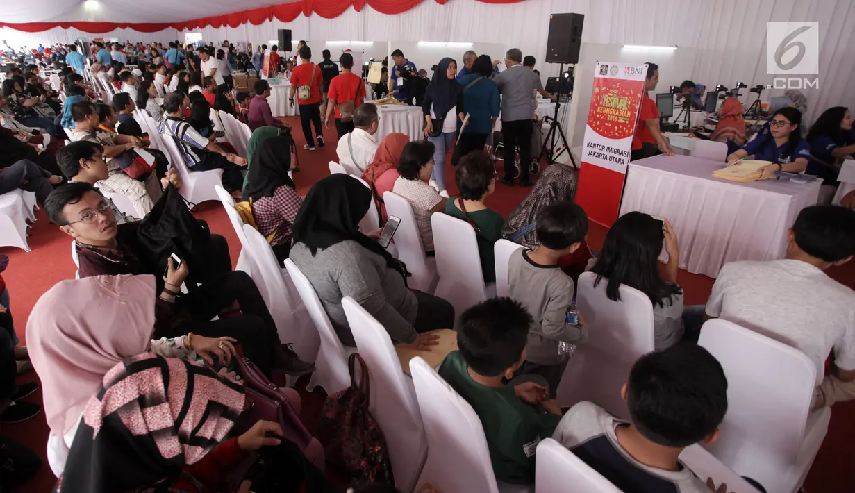 Sejumlah warga menunggu untuk pembuatan paspor dalam Festival Keimigrasian di Lapangan Barat Daya Monas, Jakarta, Minggu (21/1). Layanan ini meliputi permohonan baru paspor elektronik dan penggantian paspor biasa ke elektronik (Liputan6.com/Arya Manggala)
