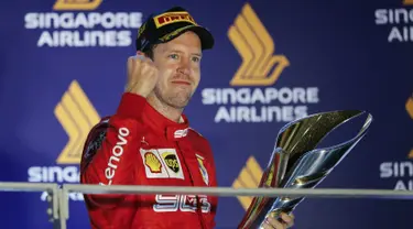 Pembalap Ferrari Sebastian Vettel berselebrasi di podium setelah memenangkan balapan Formula Satu (F1) Grand Prix Singapura di Sirkuit Jalan Marina Bay, Singapura (22/9/2019). Vettel berhasil menjuarai balapan dengan catatan waktu 1 jam:58menit:33.667 detik. (AP Photo/Vincent Thian)