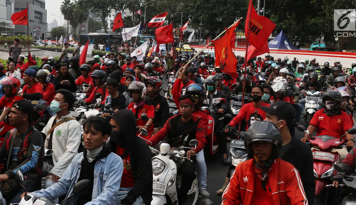 Massa dari berbagai elemen melintasi Bundaran Hotel Indonesia (HI) menuju gedung DPR, Jakarta, Selasa (25/9/2019). Sambil membawa berbagai atribut, mereka akan menggelar aksi unjuk rasa di depan DPR menolak sejumlah revisi dan rancangan UU yang menuai polemik. (Liputan6.com/Angga Yuniar)