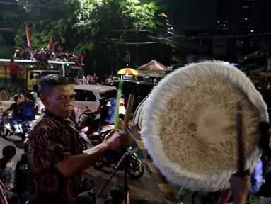Warga menabuh beduk saat memeriahkan malam takbiran di sepanjang Jalan Mas Mansyur, Tanah Abang, Jakarta Pusat, Kamis (14/6) malam. Pemerintah menetapkan 1 Syawal 1439 Hijriah atau Idul Fitri jatuh pada Jumat (15/6) besok. (Liputan6.com/Johan Tallo)