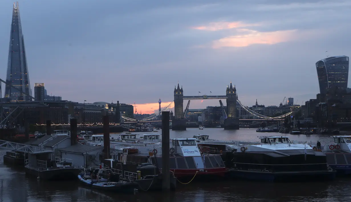 Pemandangan Tower Bridge, tengah, di Sungai Thames saat matahari terbenam di London pada Senin (9/8/2021). Tower Bridge London macet terbuka karena kesalahan teknis mengakibatkan gangguan lalu lintas di kedua sisi Sungai Thames karena mobil dan pejalan kaki tidak dapat menyeberang. (AP/Tony Hicks)