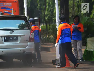 Petugas saat melakukan uji emisi mobil di Kalibata, Jakarta, Rabu (24/7). Uji emisi kendaraan di lakukan untuk kadar kualitas udara perkotaan, seiring meningkatnya volume kendaraan bermotor di kota-kota besar. (Merdeka.com/Imam Buhori)