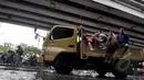 Sejumlah orang berusaha menaiki truk yang lewat untuk menumpang melawati banjir, Jakarta, Senin (6/2/2015).  Hujan yang turun sejak malam hingga kini membuat sejumlah ruas jalan di ibukota banjir. (Liputan6.com/Faizal Fanani)