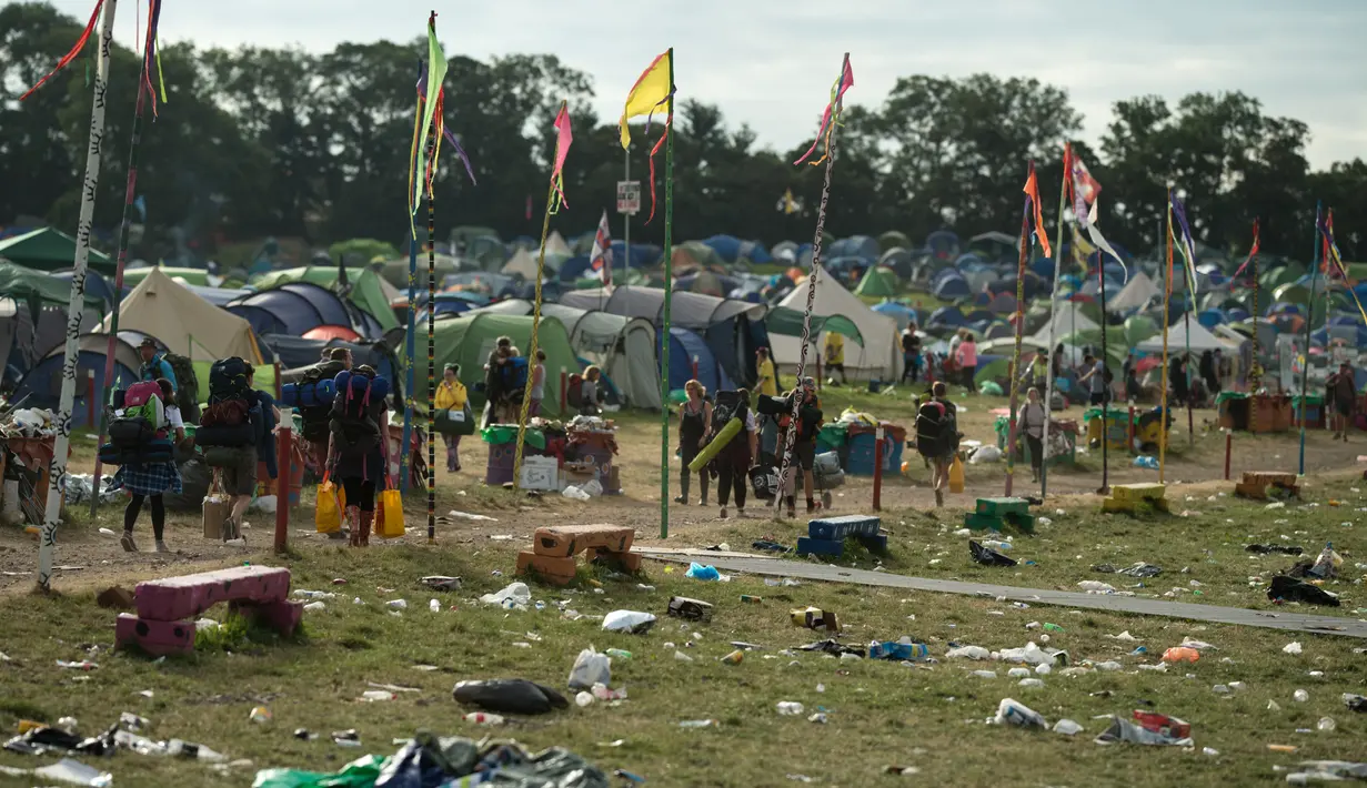 Para pengunjung bersiap meninggalkan lokasi pada akhir Festival Glastonbury di arena Worthy Farm, Inggris, 26 Juni 2017. Penyelenggaraan festival musik terbesar di dunia itu menyisakan sampah yang berserakan di seluruh arena. (OLI SCARFF/AFP)