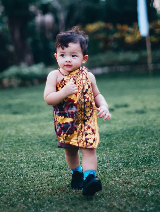 Begitu juga dengan Arsya yang berbalut kain bermotif ciri khas daerah Bali. Bibir mungil yang menggemaskan membuat Arsya tak bosan untuk dilihat. (Instagram/arsy.arsya)